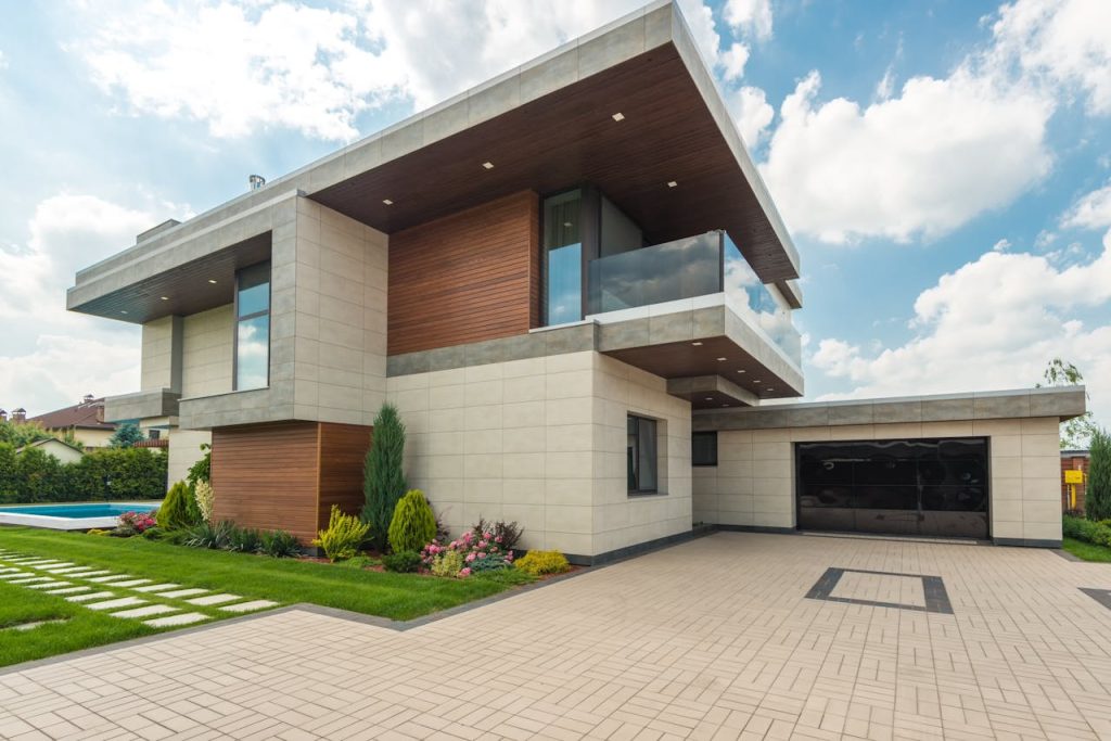 brown-and-white-wooden-house-under-blue-sky-8134847 Contemporary luxury house with a sleek design, lush garden, and blue sky.