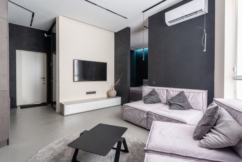 cozy-living-room-with-sofas-and-television-set-6316067 Spacious and stylish modern living room with sleek furnishings and minimalistic decor.