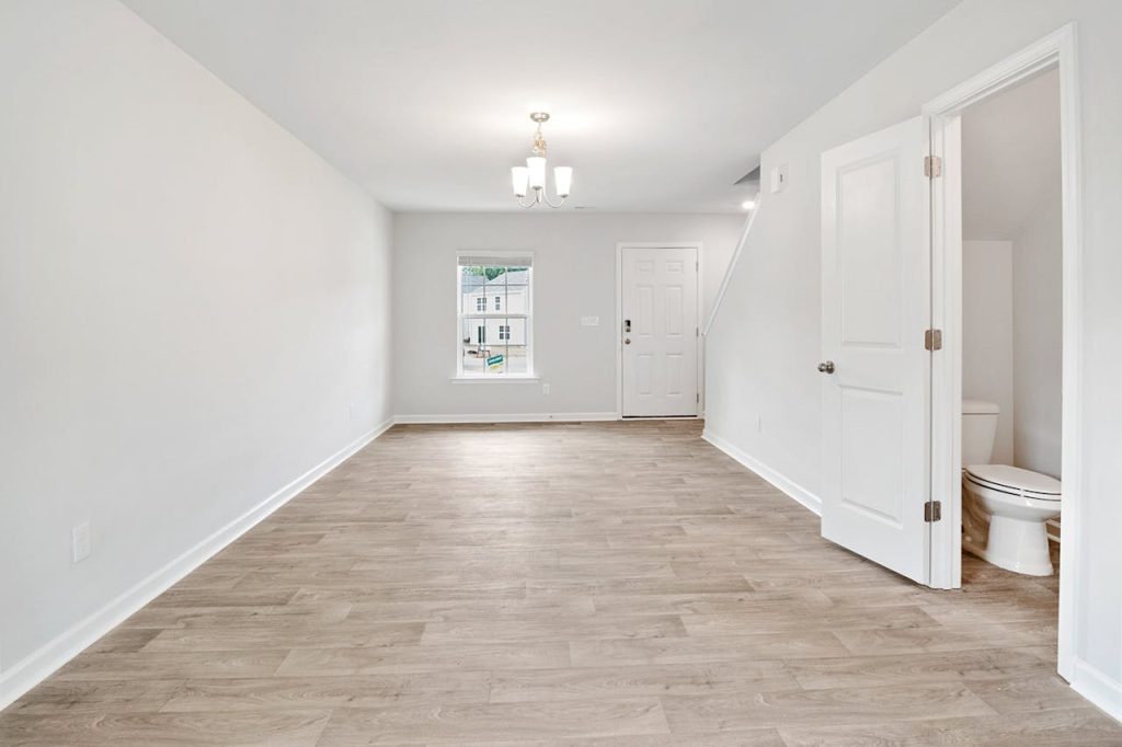 photo-of-an-empty-living-room-4832514 Bright and open living room with wooden floors, ideal for modern living.