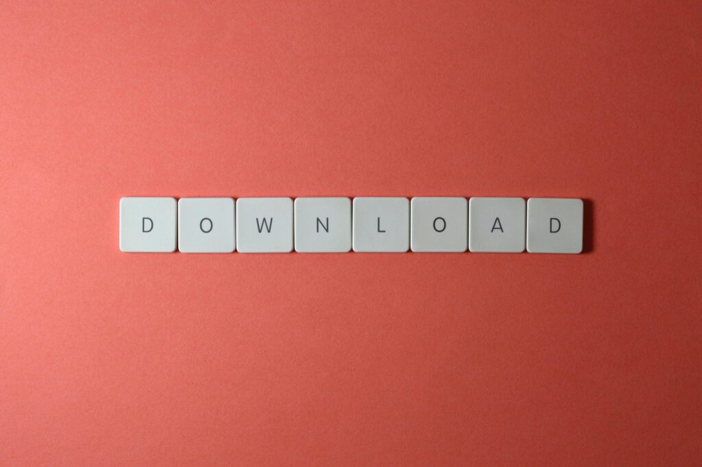 pexels-photo-2882550-2882550 Minimalist photo of keyboard tiles spelling 'DOWNLOAD' on a red background.