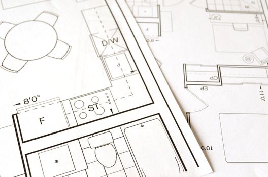 Close-up view von an architectural floor plan on paper showcasing detailed room layouts and measurements.